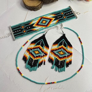 May include: A turquoise, black, white, orange and yellow beaded necklace, bracelet and earrings set with a geometric pattern.
