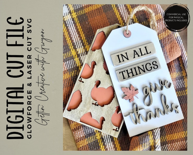 May include: A wooden tag with the text "In All Things Give Thanks" and a small maple leaf. The tag is on a plaid fabric background.