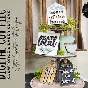May include: A tiered wooden stand with four signs. The top sign is white with green leaves and says "heart of the home". The middle sign is white with green leaves and says "eat local". The bottom sign is black with white text and says "MENU take it OR leave it".