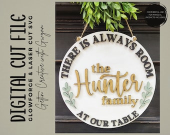 May include: A white round wooden sign with black lettering that reads "There is always room at our table, the Hunter family". The sign has a gold and green leafy design around the text.