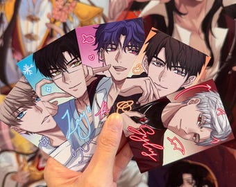 May include: A hand displays a collection of anime-style character art cards. Each card showcases a different male character with distinct hair and eye colours. The cards feature decorative icons and text, with a blurred background of similar artwork.