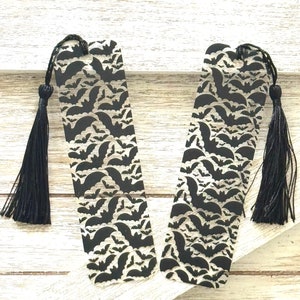 May include: Two black and white acrylic bookmarks with a bat pattern and black tassels.