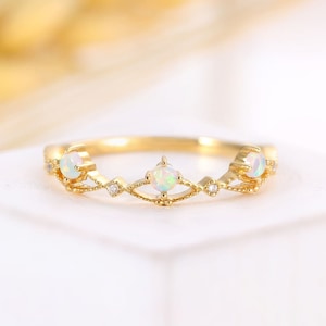May include: A delicate gold ring with a delicate filigree design and three opal stones.