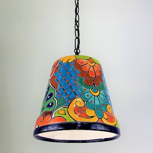 May include: A colorful ceramic pendant light with a floral pattern in shades of blue, green, orange, and red. The light is suspended from a black chain.