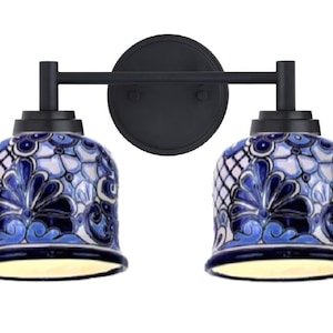 May include: A black metal double vanity light fixture with two blue and white ceramic shades featuring a floral pattern.