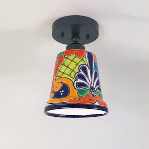 May include: A colorful ceramic ceiling light fixture with a bell-shaped shade featuring a traditional Mexican Talavera pattern in shades of blue, green, orange, and yellow.