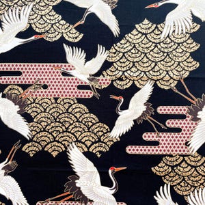 以下が含まれることがあります： 黒地に、白い鶴が金と赤紫の雲の上を飛んでいる模様が繰り返されている。鶴は黒い足とくちばしをしている。