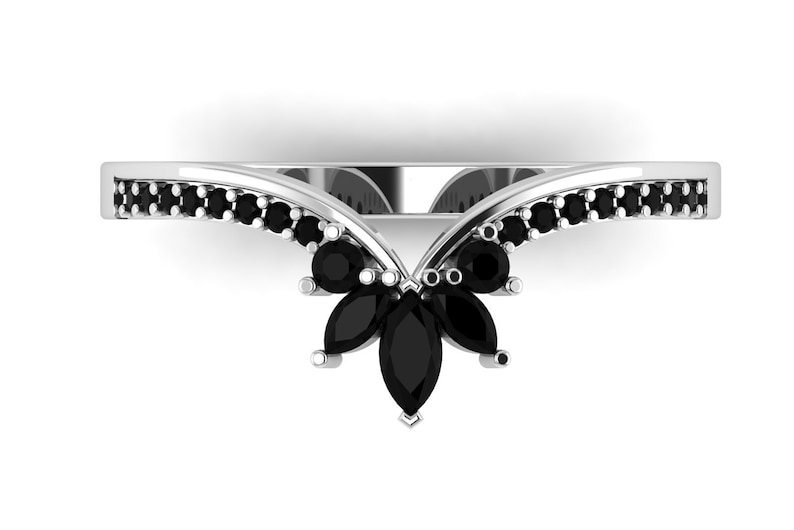 May include: A silver ring with a V-shaped band set with black marquise-shaped gemstones. The band is lined with smaller black round gemstones.