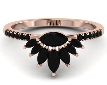May include: Rose gold ring featuring a fan-shaped design of black gemstones. The band is lined with small black stones. The central design is a marquise-cut black stone, with smaller, teardrop-shaped stones fanning out below.