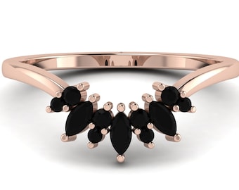 May include: A rose gold wedding band with a curved design and black marquise and round diamonds.
