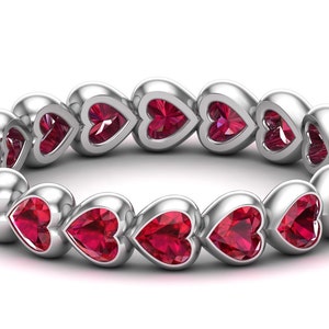 Peut inclure: Une bague en argent avec une rangée de pierres précieuses en forme de cœur en rubis.