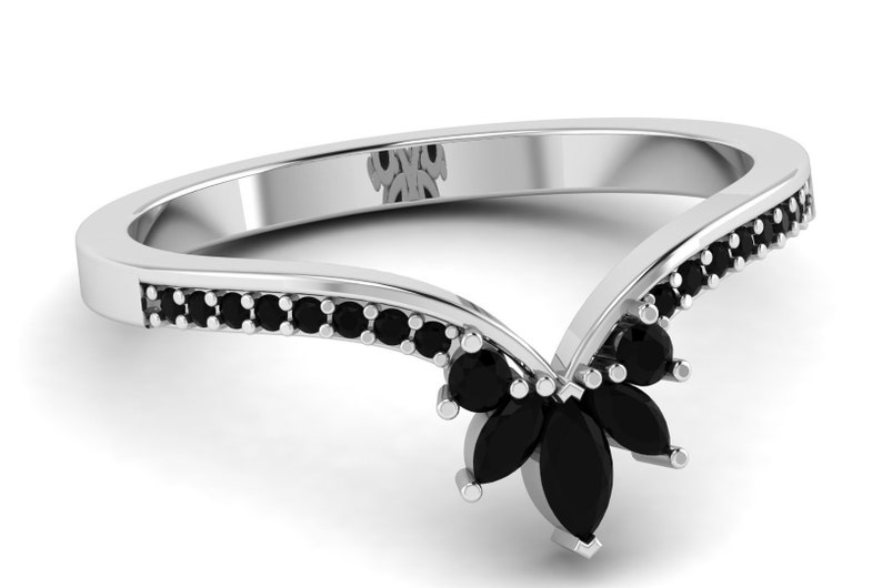 May include: A silver ring with a V-shaped band set with black marquise-shaped stones. The band is accented with smaller black round stones.