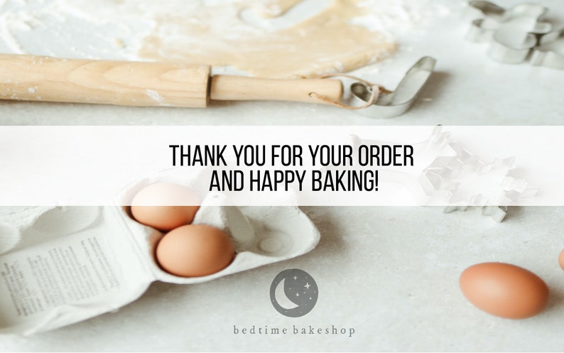 May include: A white countertop with baking supplies, including a rolling pin, cookie cutters, a carton of eggs, and a handwritten sign that reads "THANK YOU FOR YOUR ORDER AND HAPPY BAKING!" The sign is above a white carton of eggs with a gray moon and stars logo that reads "bedtime bakeshop".