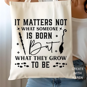 May include: Cream-colored tote bag with black text that reads "IT MATTERS NOT WHAT SOMEONE IS BORN But WHAT THEY GROW TO BE." The design includes a wand, a broom, and footprints. The bag is held by a person.