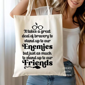 May include: Cream-colored tote bag with black text that reads "It takes a great deal of bravery to stand up to our Enemies but just as much to stand up to our Friends." The bag also features a lightning bolt and glasses graphic.