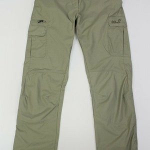 Peut inclure: Un pantalon cargo vert clair avec deux grandes poches sur les côtés et une petite poche sur la jambe droite. Le pantalon a une fermeture éclair et un bouton.