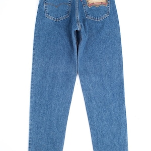 Może przedstawiać: Dżinsy z niebieskiego denimu z metką Levi's 550 Relaxed Fit na tylnej kieszeni.