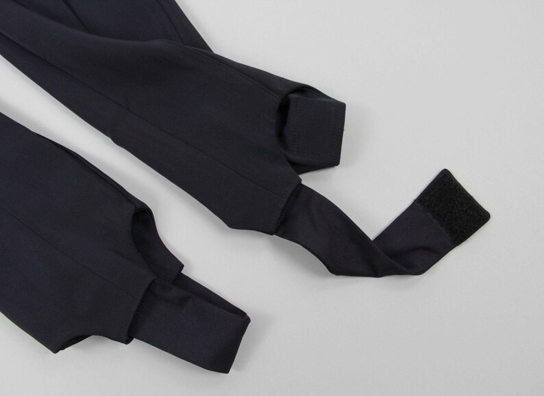 Puede incluir: Primer plano de leggings azul marino con estribos. Los leggings tienen un dise&ntilde;o elegante con una correa de estribo en la parte inferior de cada pierna. La tela parece suave y tiene un ligero brillo. Las correas de estribo est&aacute;n dise&ntilde;adas para ir debajo del pie.