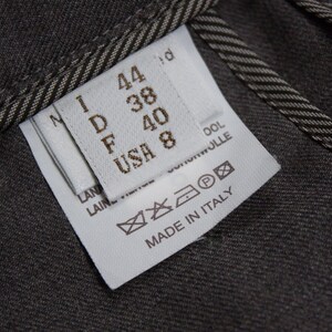 Puede incluir: Una etiqueta de ropa blanca con texto negro y s&iacute;mbolos. La etiqueta muestra informaci&oacute;n de talla en diferentes sistemas de tallas: I 44, D 38, F 40, USA 8. La etiqueta tambi&eacute;n incluye instrucciones de cuidado y el texto "Made in Italy".