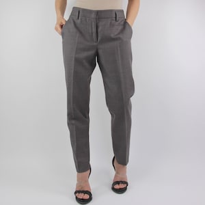 Puede incluir: Pantal&oacute;n gris de corte sastre con pierna recta. El pantal&oacute;n tiene cierre de cremallera y trabillas para cintur&oacute;n.