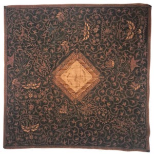 Könnte beinhalten: Ein quadratisches Textil mit dunkelbraunem Hintergrund und einem komplizierten, sich wiederholenden Muster aus hellbraunen Ranken, Blättern und stilisierten Vogelmotiven. Ein großes, zentrales Rautenmuster in hellem Beige liegt in der Mitte.