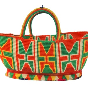 May include: A woven basket with a red, green, yellow and white geometric pattern. The basket has two handles and a rounded bottom.