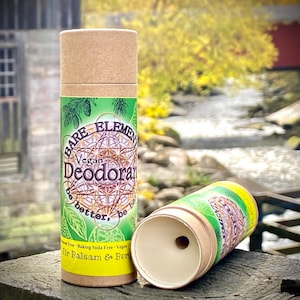 Könnte beinhalten: Zwei Pappröhren mit einem grün-weißen Etikett. Das Etikett lautet "Bare Elements Vegan Deodorant be better, be free Baking Soda Free Vegan Fir Balsam & Bergamot".