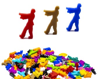 Op de afbeelding: Een verzameling kleurrijke miniatuurbeeldjes in verschillende vormen en maten. Drie beeldjes zijn rood, bruin en blauw en beelden een persoon uit die een pistool vasthoudt. De rest van de beeldjes is in verschillende kleuren, waaronder geel, groen en paars.