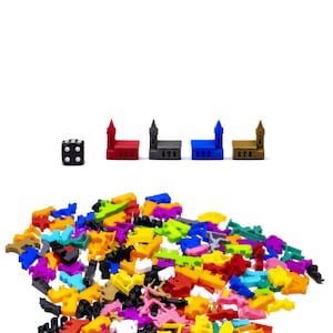 May include: A black die with white dots, and five colourful plastic buildings with pointed roofs. A large pile of colourful plastic pieces in various shapes and sizes.