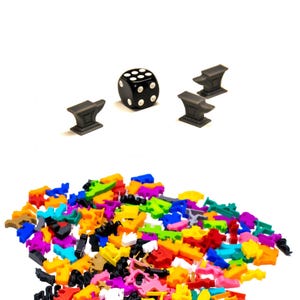 May include: A black six-sided die with white dots, three gray metal anvils, and a large pile of colorful plastic game pieces.