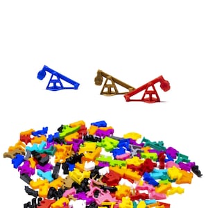 Puede incluir: Una colección de piezas de juego de plástico de colores vivos, incluyendo una balancín azul, marrón y rojo. Las piezas están esparcidas sobre una superficie blanca.