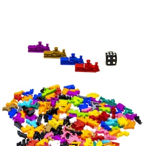 May include: A collection of colorful plastic train pieces and a black die. The train pieces are in various colors, including red, blue, green, yellow, and purple. The die has white dots on each side.