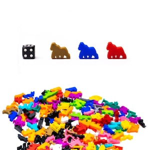 Könnte beinhalten: Ein schwarzer sechsseitiger Würfel mit weißen Punkten, drei braune, blaue und rote Tierfiguren aus Plastik und ein großer Haufen bunter Tierfiguren aus Plastik.