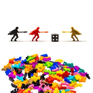 Pode incluir: Um monte de peças de jogo de plástico coloridas, incluindo vermelho, amarelo, azul, verde e preto. Há três figuras em miniatura no fundo, uma preta, uma vermelha e uma dourada, cada uma segurando uma lança e olhando para um dado preto de seis lados.