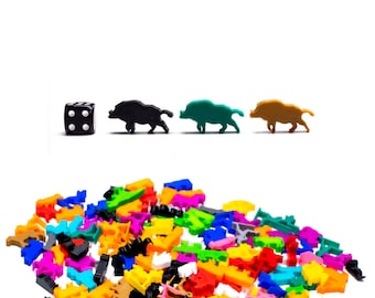 Op de afbeelding: Een zwarte dobbelsteen met witte stippen, drie zwarte plastic everzwijnfiguren en een stapel kleurrijke plastic everzwijnfiguren.