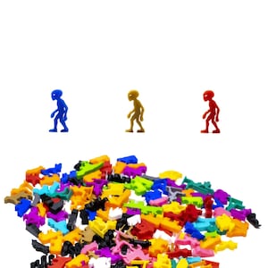 May include: A collection of colorful plastic toy pieces, including small, humanoid figures in blue, gold, and red. The assortment of shapes and colors suggests a building or crafting set, ideal for creative play.