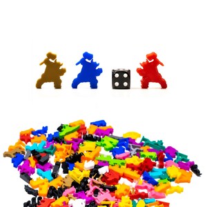 May include: A pile of colorful plastic game pieces, including brown, blue, red, and yellow. A single black die with white dots is in the center of the image.