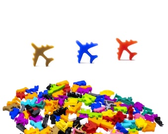 Puede incluir: Un montón grande de juguetes de avión de plástico de colores variados, incluyendo rojo, azul, verde, amarillo, naranja y marrón. Tres aviones más grandes son visibles en el fondo, uno marrón, uno azul y uno rojo.