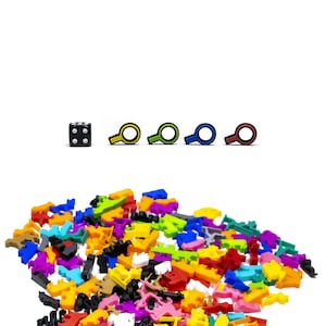 May include: A black die with white dots, four magnifying glasses in different colours, and a pile of colourful plastic game pieces.