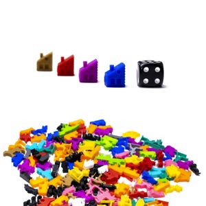May include: A black dice with four dots on one side, next to a row of five colorful plastic houses. The houses are brown, red, purple, blue, and green. A pile of colorful plastic houses is in the bottom of the image.