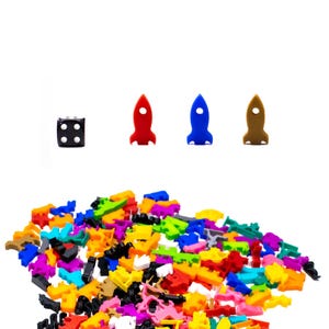 May include: A pile of colorful plastic rocket shaped game pieces with a black die and three red, blue, and brown rockets.