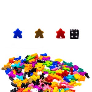 May include: A pile of colourful plastic game pieces, including blue, red, brown, and black. There are three star-shaped pieces and one black die with white dots.