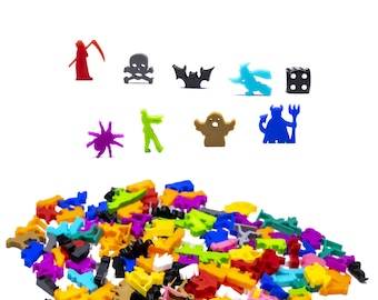 May include: A collection of colourful plastic Halloween-themed game pieces, including a spider, a ghost, a zombie, a devil, a bat, a skull, a grim reaper, a witch, and a die. The pieces are scattered on a white surface.