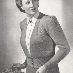 Könnte beinhalten: Ein grauer Strickcardigan mit V-Ausschnitt und Knopfleiste. Der Cardigan hat ein strukturiertes Muster auf der Vorderseite und den Ärmeln.
