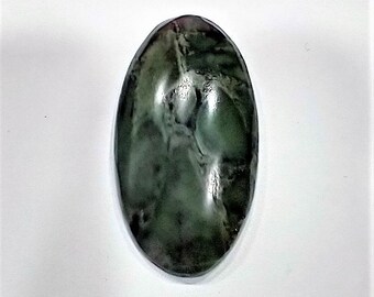 May include: An oval-shaped, polished gemstone with a dark green hue and a marbled appearance. The stone has a smooth, glossy surface and a slightly translucent quality, with variations in color and texture throughout.