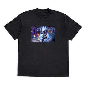 Könnte beinhalten: Schwarzes T-Shirt mit einem Grafikdruck einer Person in einem blauen und violetten Anzug, die in einer Stadtstraße steht. Die Grafik ist von einem weißen Rand umgeben.