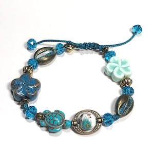 Beaded Sweet turquoise, teal, seafoam green, turtle w ceramic flower, glass, and crystal beads-adjustable bracelet or anklet.