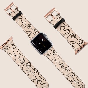 May include: A set of two watch bands with a rose gold buckle and a cream-colored leather strap with a black abstract pattern.