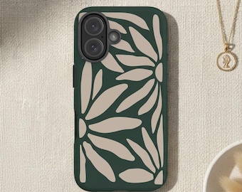 May include: A dark green phone case with a repeating pattern of large, beige daisy-like floral shapes. The case has a dual-camera setup. A gold necklace with a pendant and a small white dish with dried flowers are also visible.
