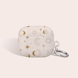 Peut inclure: Un étui blanc pour Airpods avec un motif céleste doré représentant des lunes, des étoiles et des soleils. L'étui est doté d'un porte-clés en métal argenté.